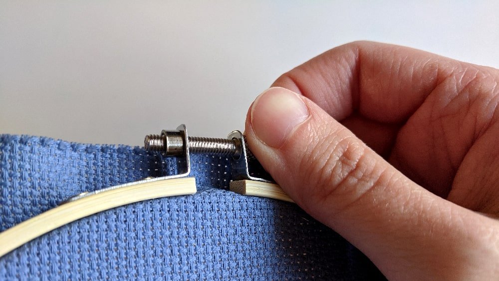 Tighten the screw to hold the fabric