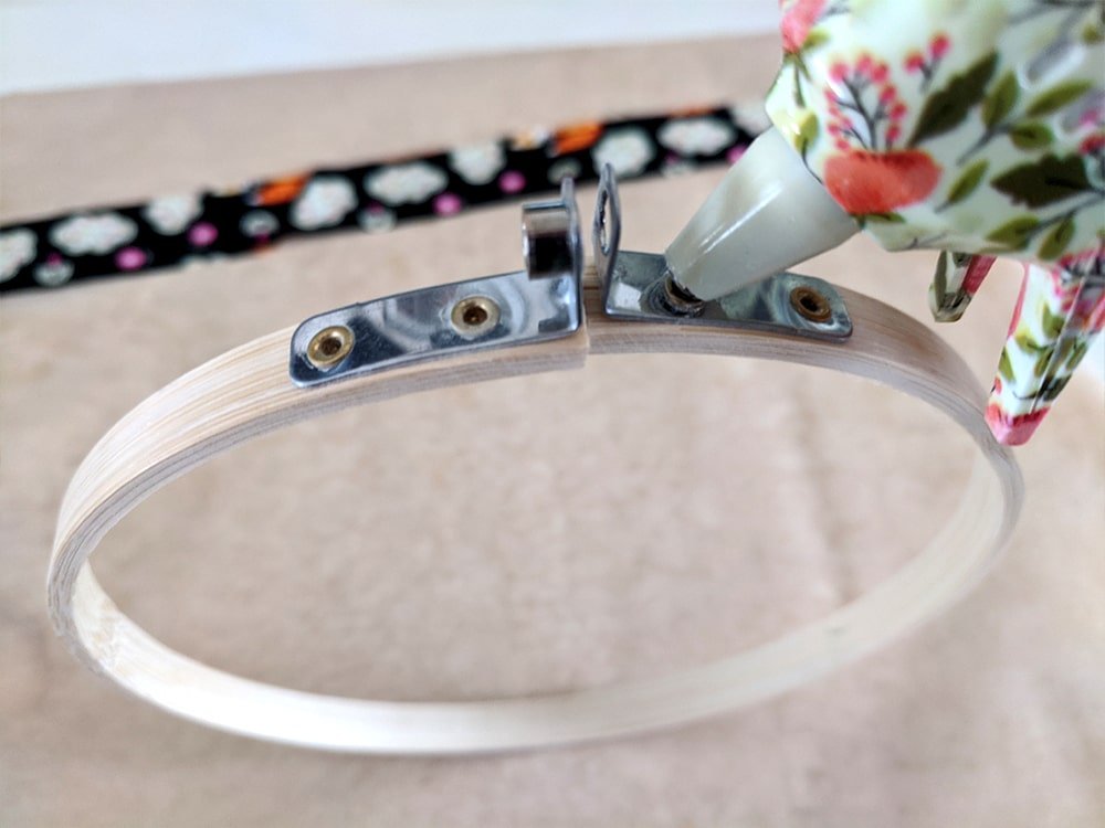 Use glue to adhere the fabric to your hoop